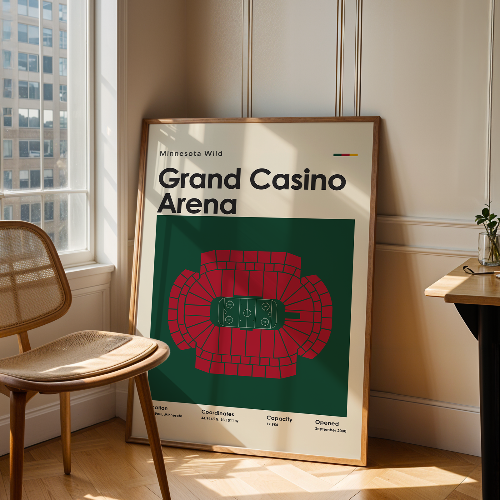 Framed poster of Grand Casino Arena in a room with a chair and table.