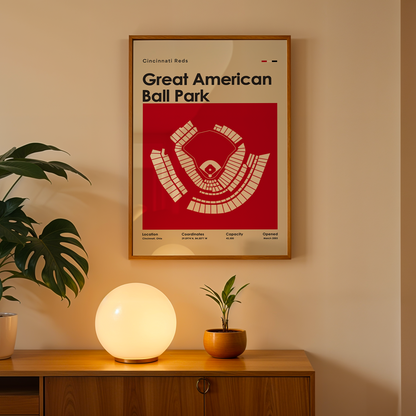 Framed poster of Great American Ball Park on a wall above a wooden cabinet with decorative items.