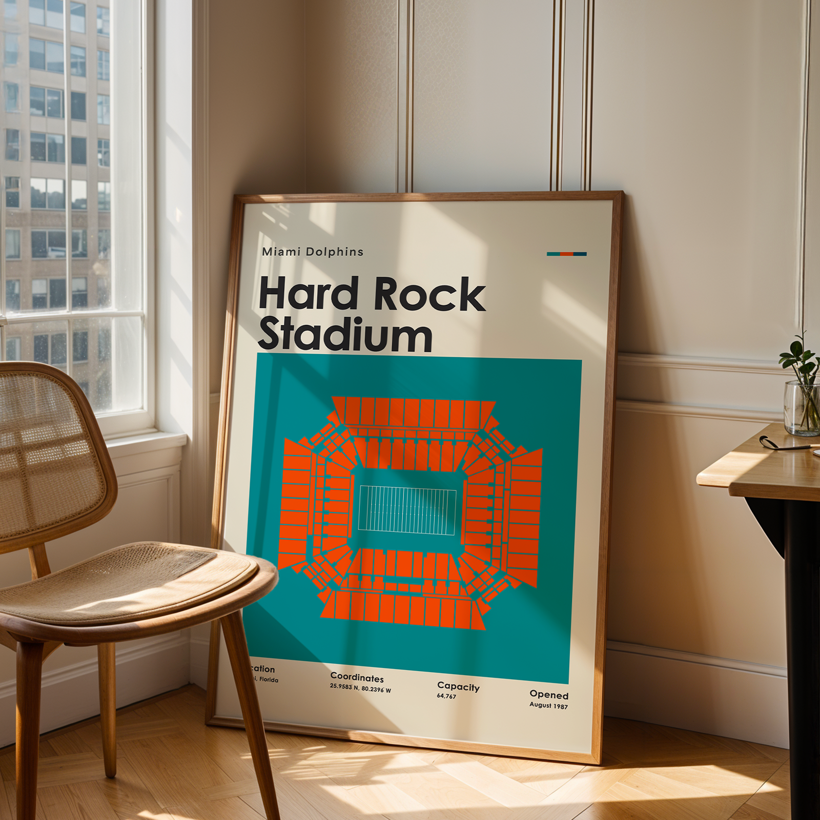 Framed poster of Hard Rock Stadium in Miami Dolphins design leaning against a wall.
