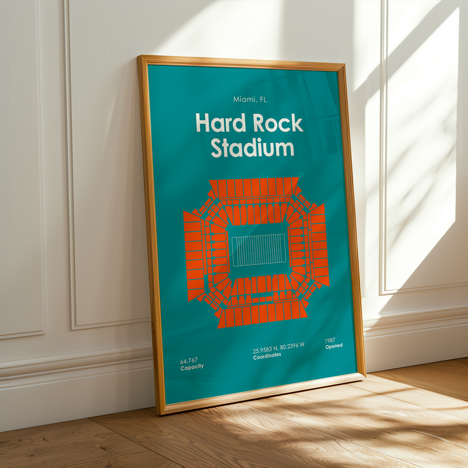 Framed poster of Hard Rock Stadium with a wooden frame on a white wall.