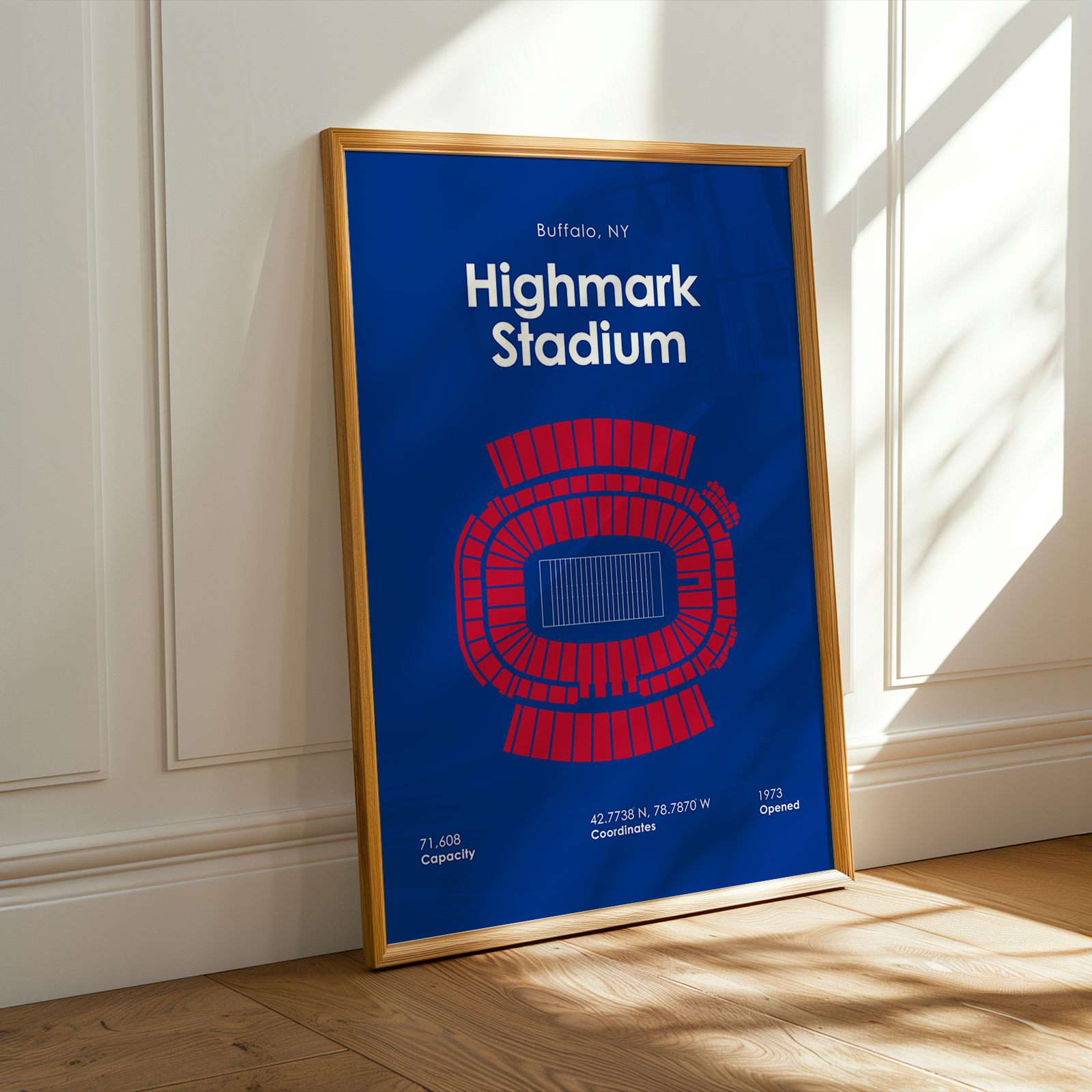 Framed poster of Highmark Stadium with blue background and red seating layout, leaning against a white wall.