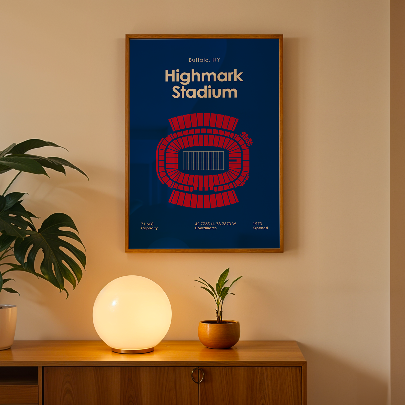 Framed poster of Highmark Stadium on a wall above a wooden cabinet with decorative items.