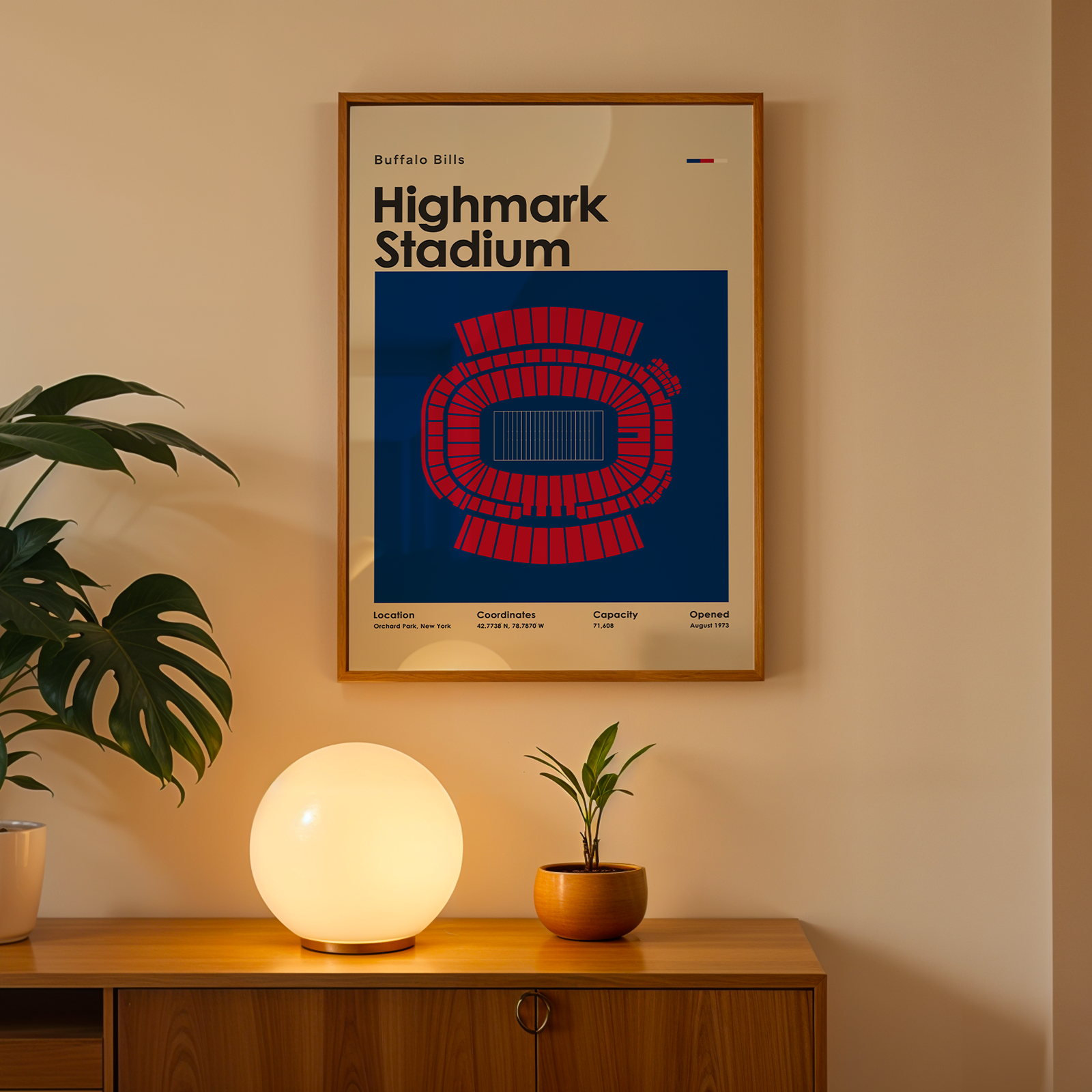 Framed poster of Highmark Stadium on a wall above a wooden cabinet with decorative items.