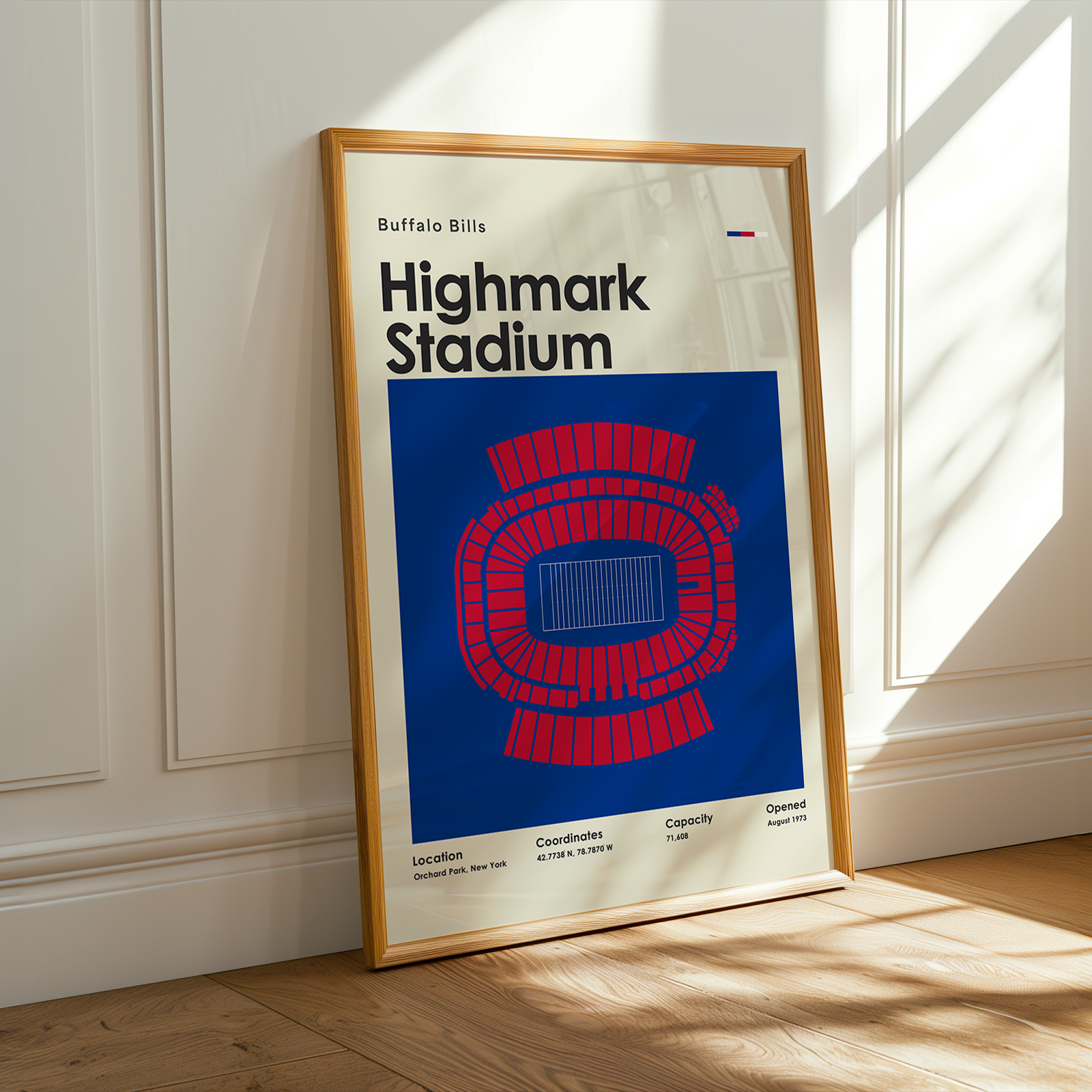 Framed poster of Highmark Stadium with a blue and red seating chart on a white background, leaning against a white wall.