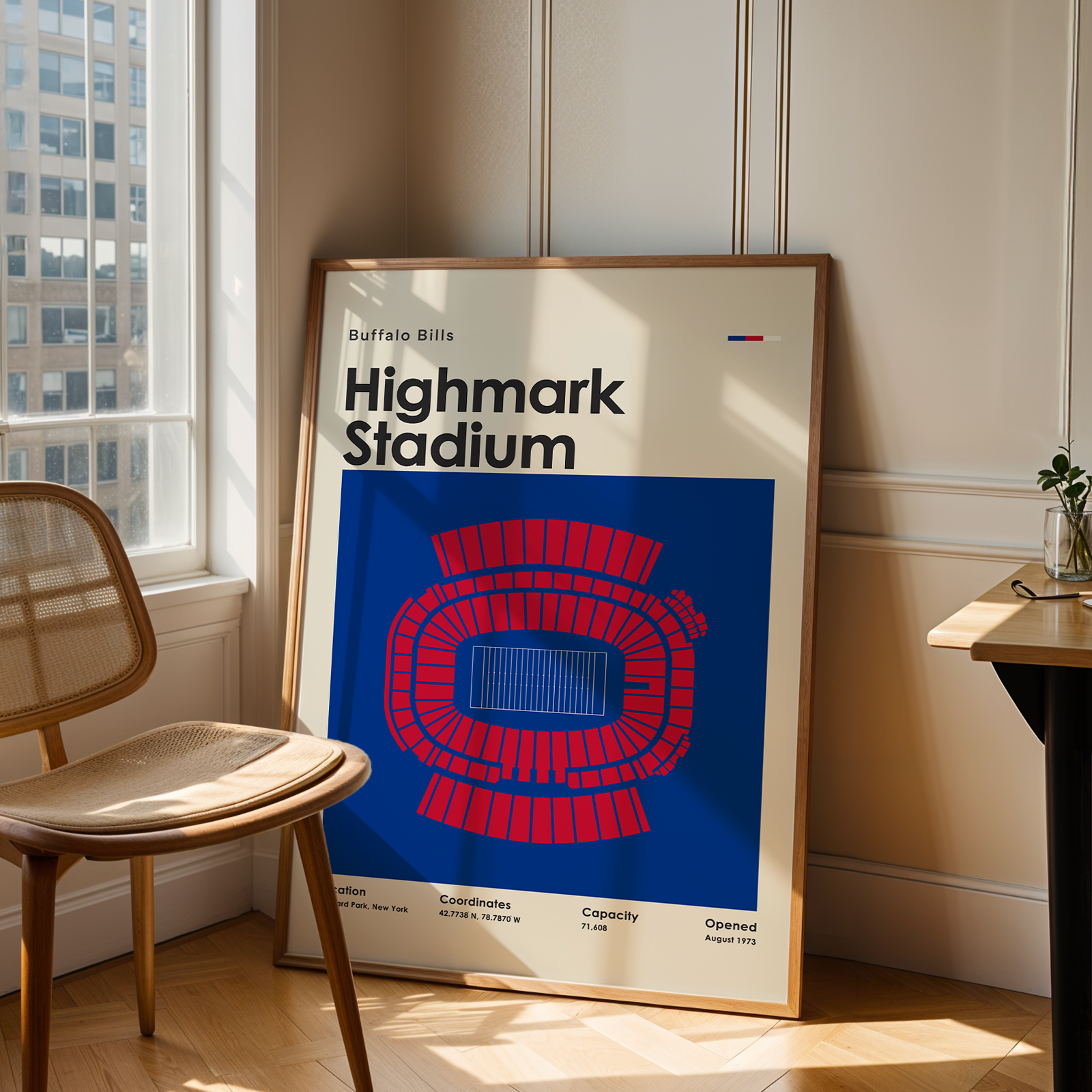 Framed poster of Highmark Stadium in a room with a window and chair.