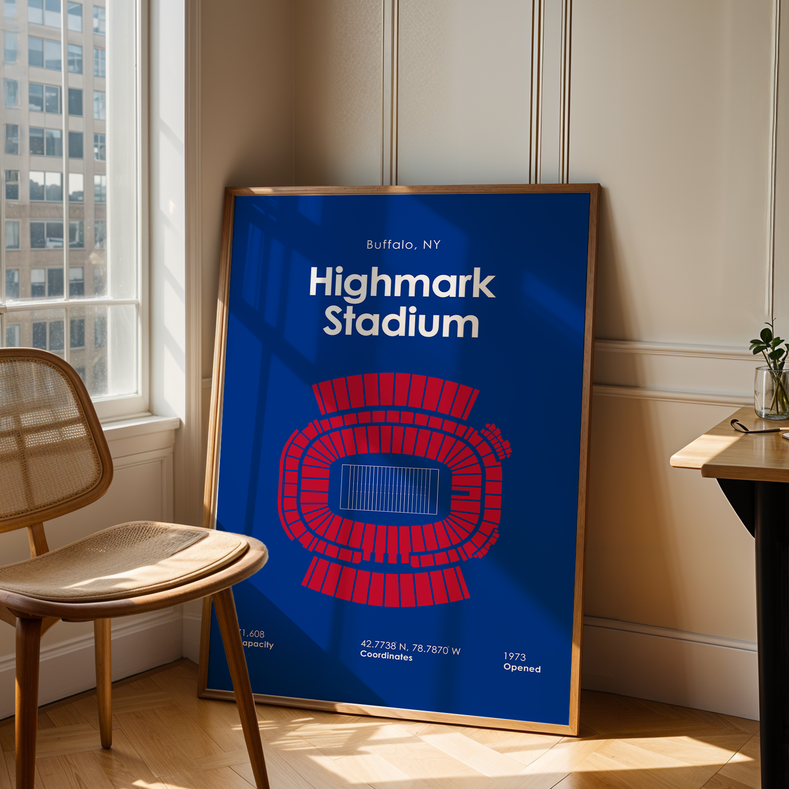 Framed poster of Highmark Stadium in a room with a chair and table.