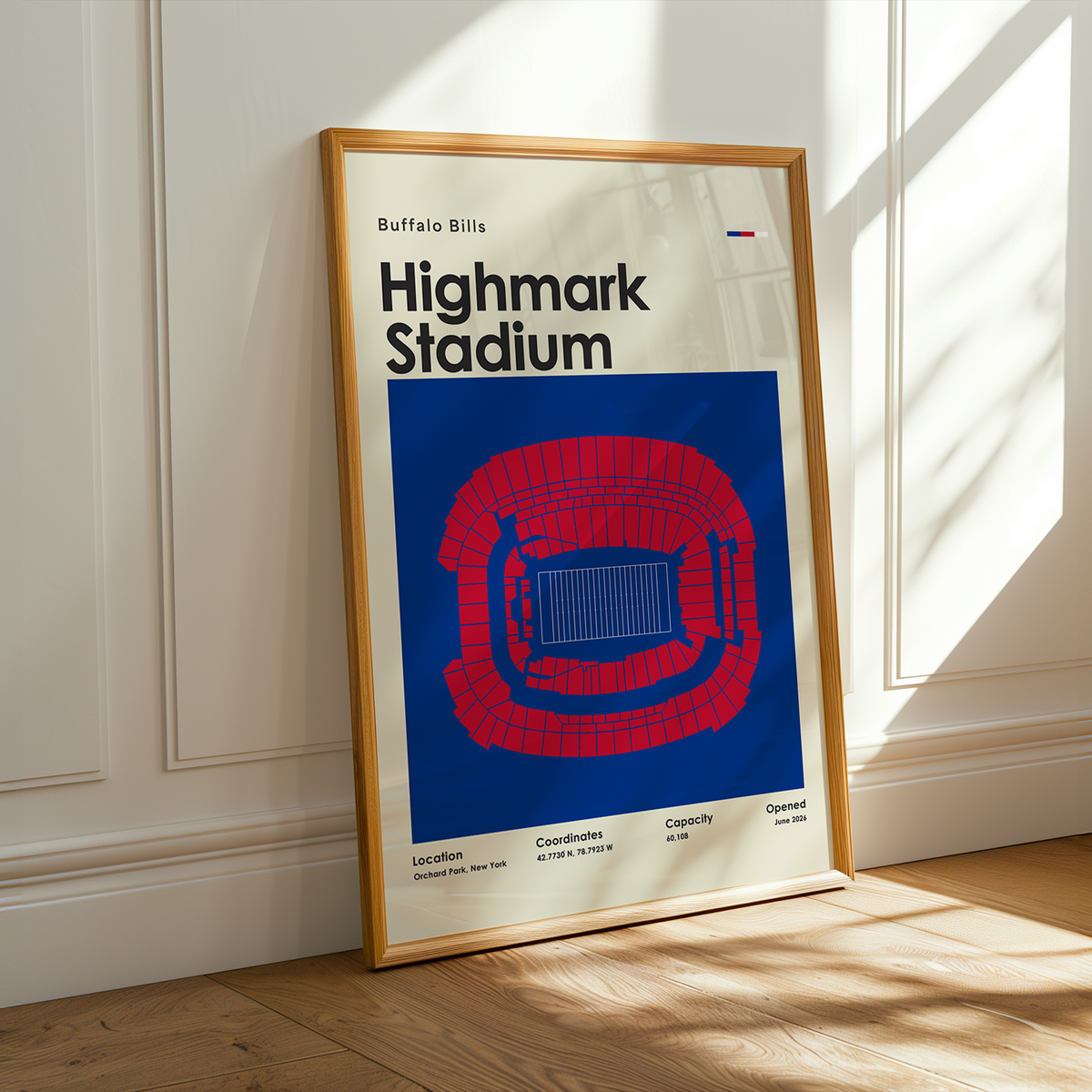 A framed Buffalo Bills Highmark Stadium sports poster leaning against a white paneled wall on a light wood floor, with warm sunlight casting shadows across the scene.
