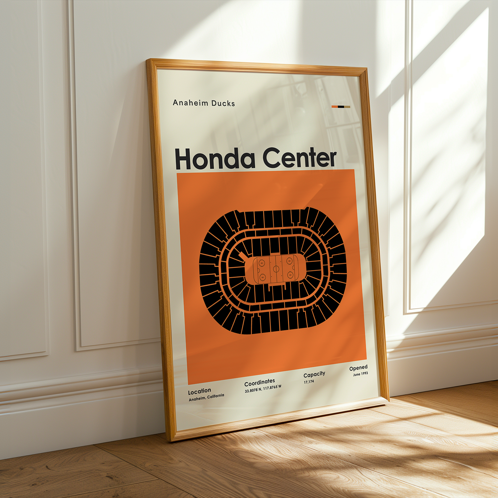Framed poster of Honda Center with orange and black design on a white wall.