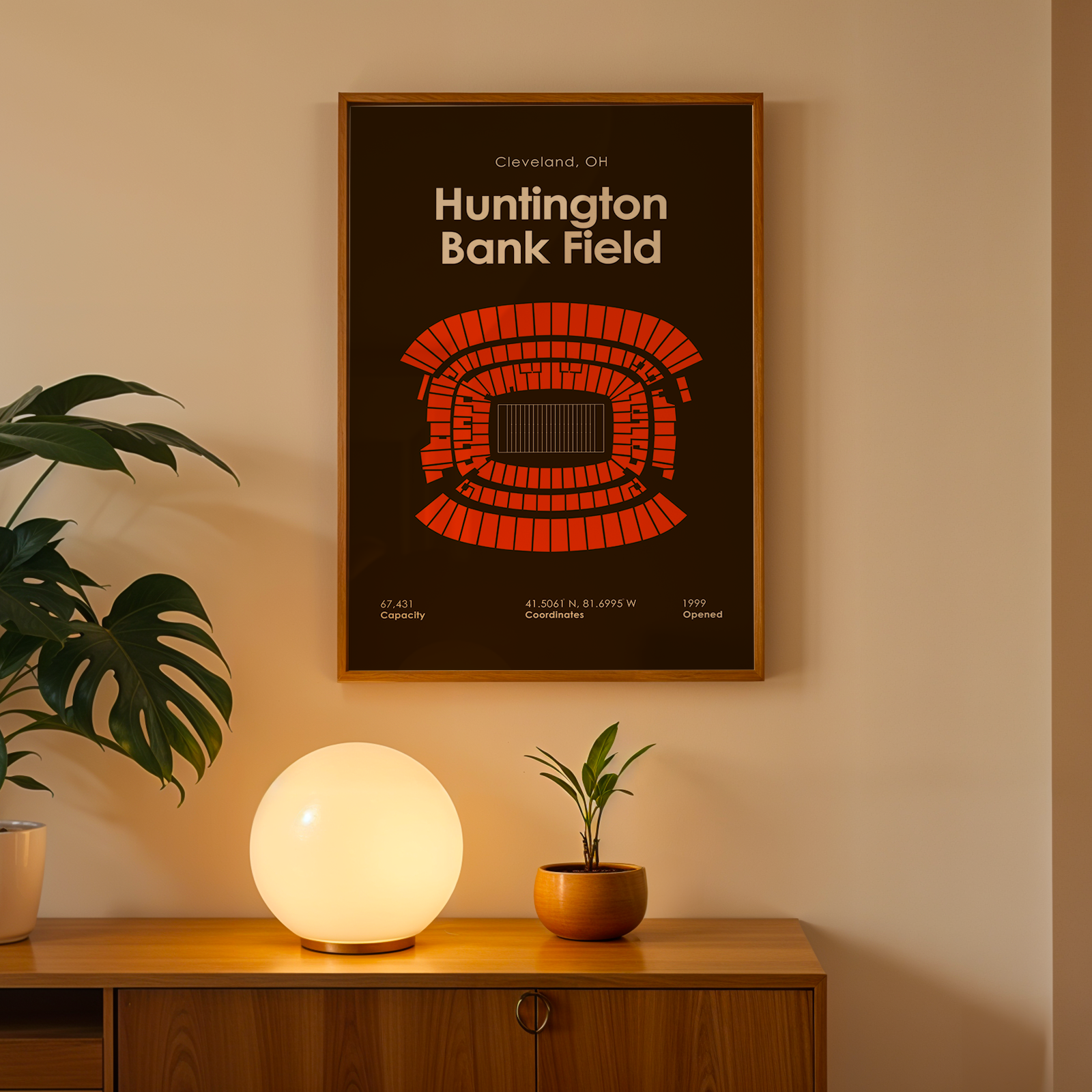 Framed poster of Huntington Bank Field on a wall above a wooden cabinet with decorative items.