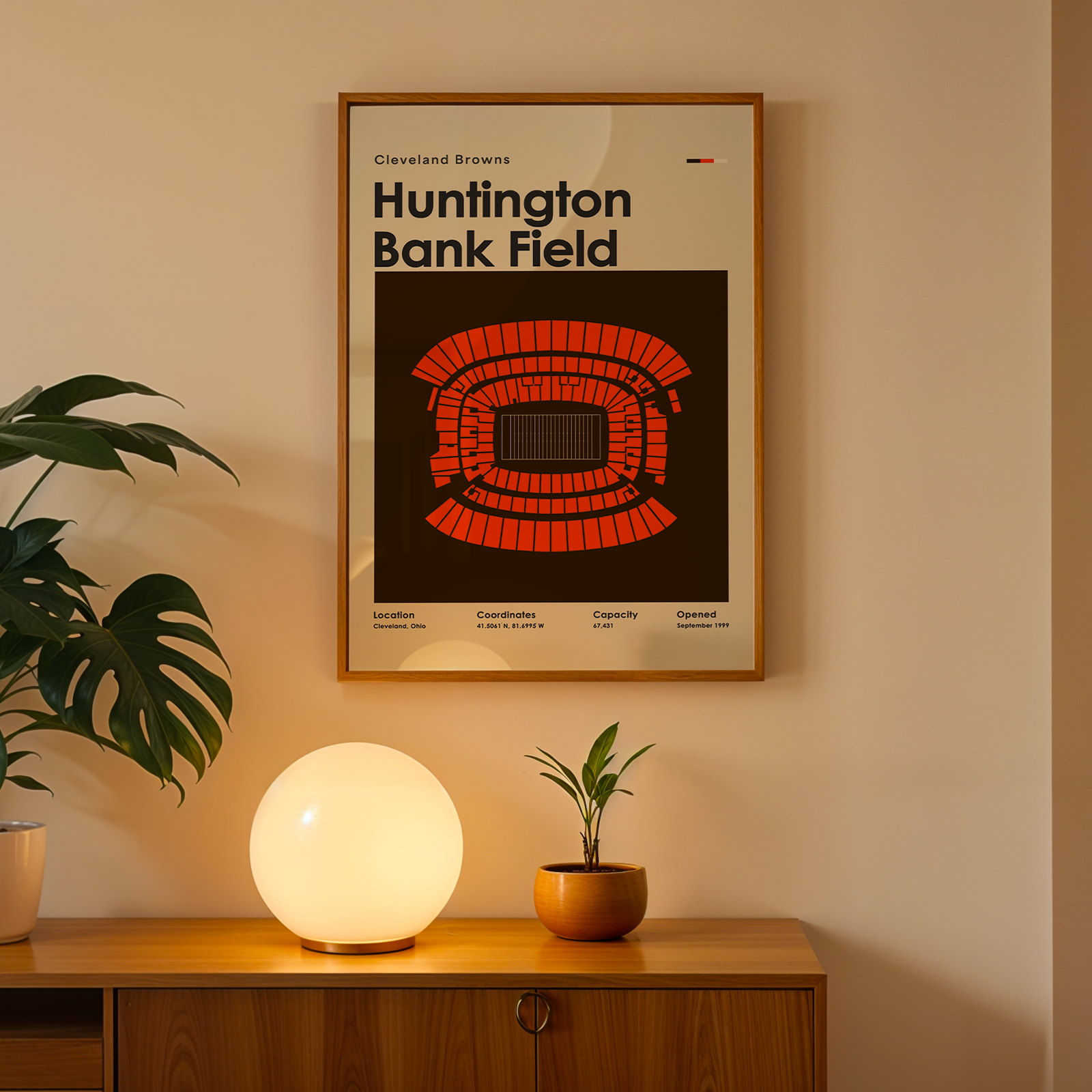 Framed poster of Huntington Bank Field on a wall above a wooden cabinet with decorative items.