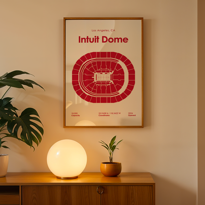 Framed 'Intuit Dome' poster on a wall above a wooden cabinet with decorative items.