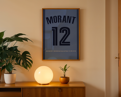 Framed poster with 'Morant 12' on a wall above a wooden cabinet with decorative items.