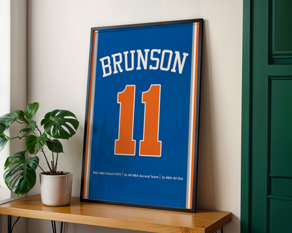 Framed sports jersey with 'Brunson' and number '11' on a wooden shelf.