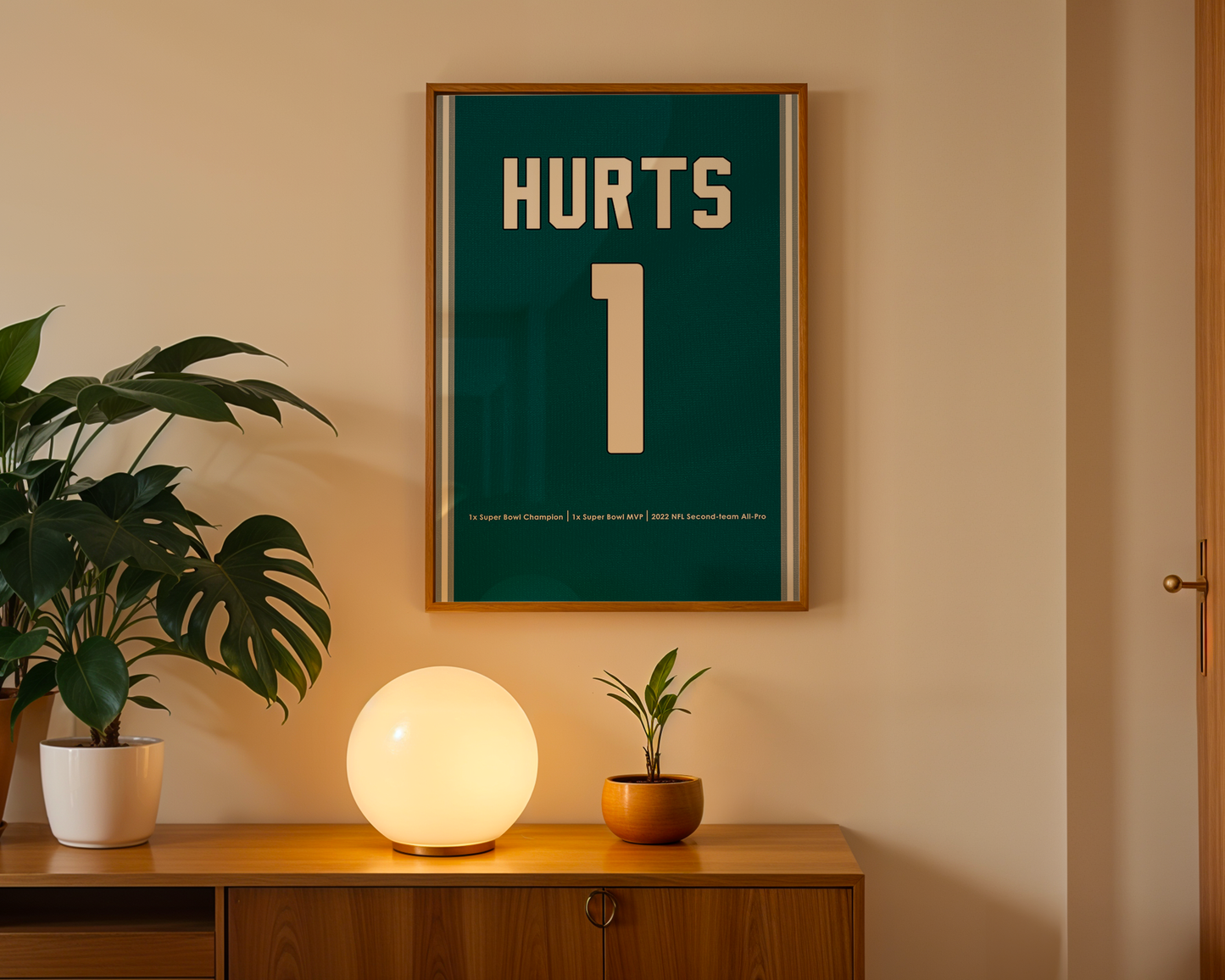 Framed poster with 'HURTS' and number '1' on a wall above a wooden cabinet with decorative items.