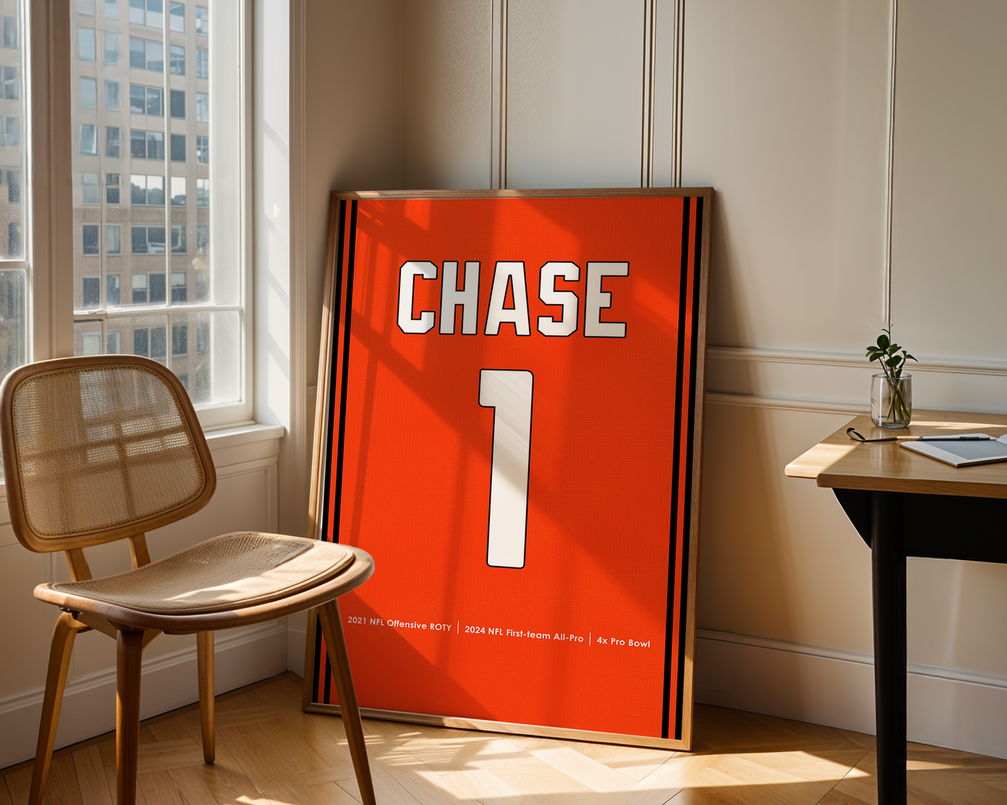 Orange sports jersey with 'CHASE 1' printed on it, leaning against a wall in a room with a chair and table.