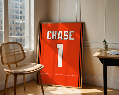 Orange sports jersey with 'CHASE 1' printed on it, leaning against a wall in a room with a chair and table.