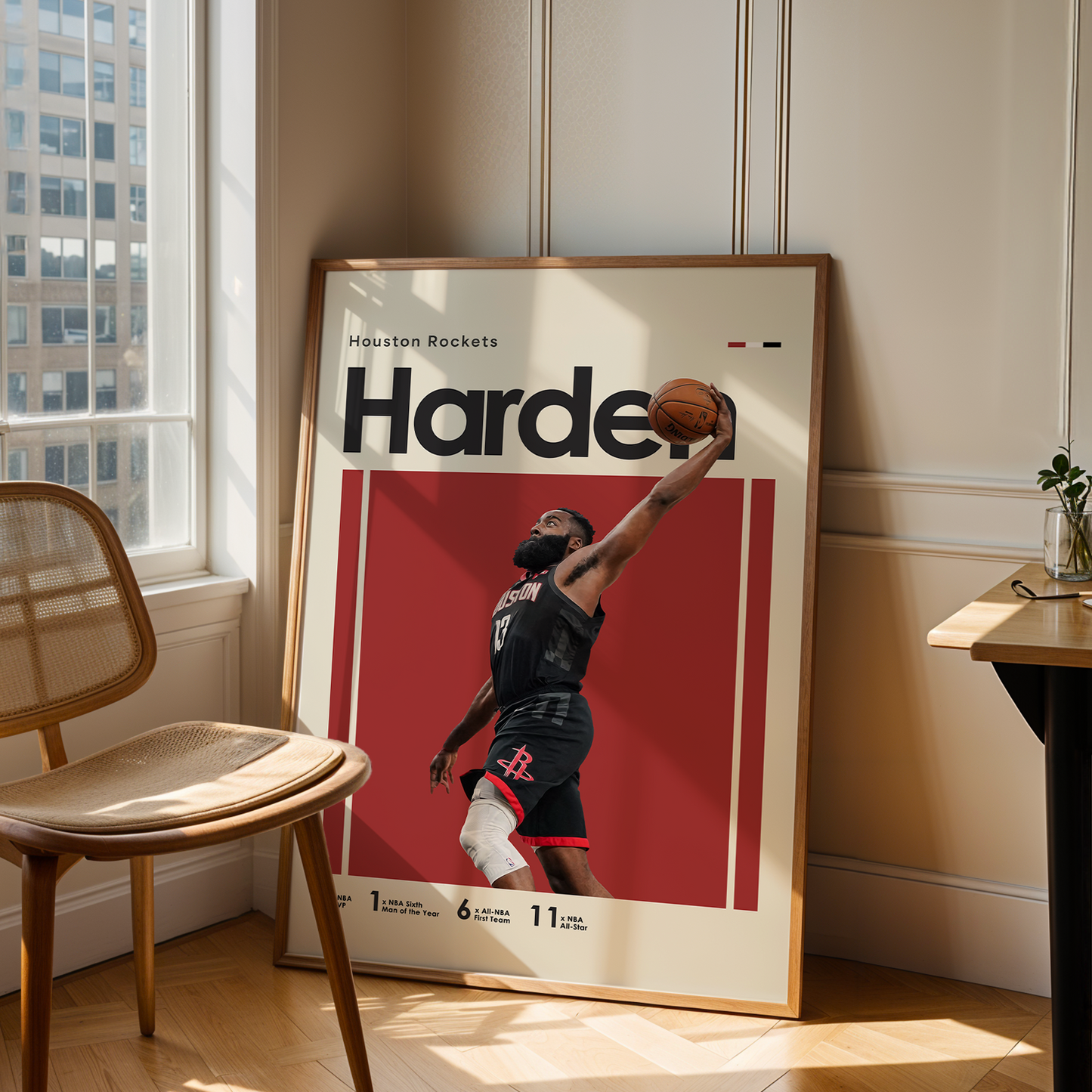 Framed poster of a basketball player in a room with a chair and table.