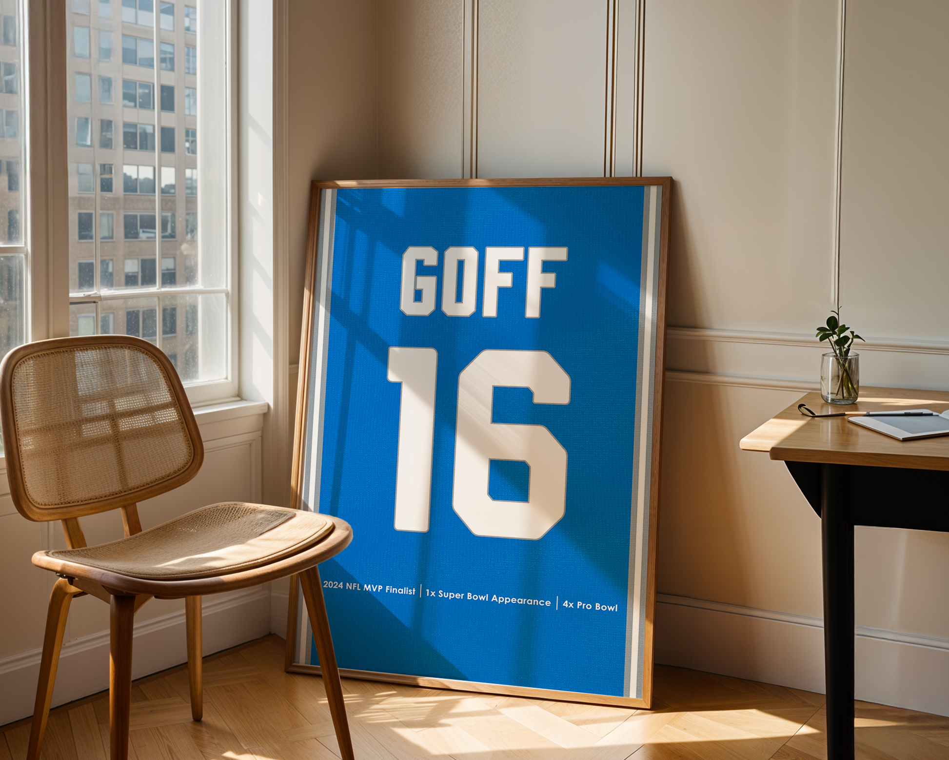 Framed sports jersey with 'GOFF 16' on a wall in a room with a chair and table.