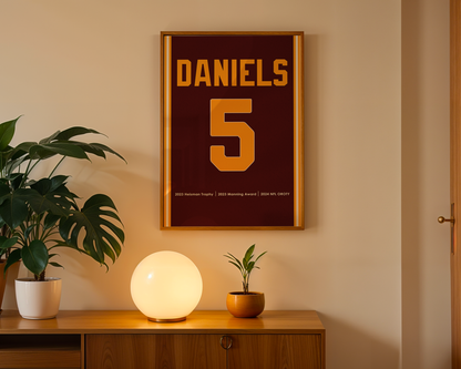 Framed poster with 'Daniels 5' on a wall above a wooden cabinet with decorative items.