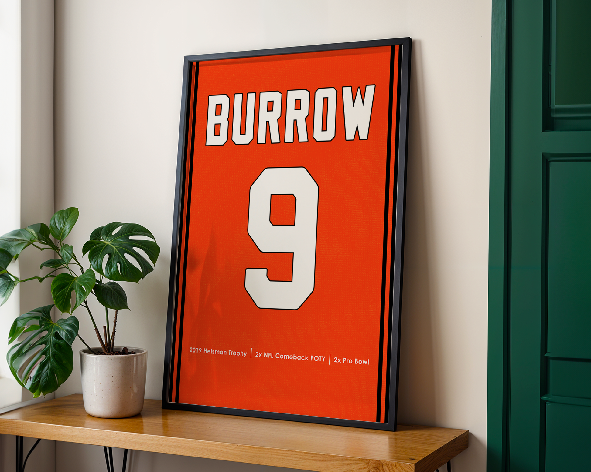 Framed sports jersey with 'Burrow' and number '9' on a wooden shelf.