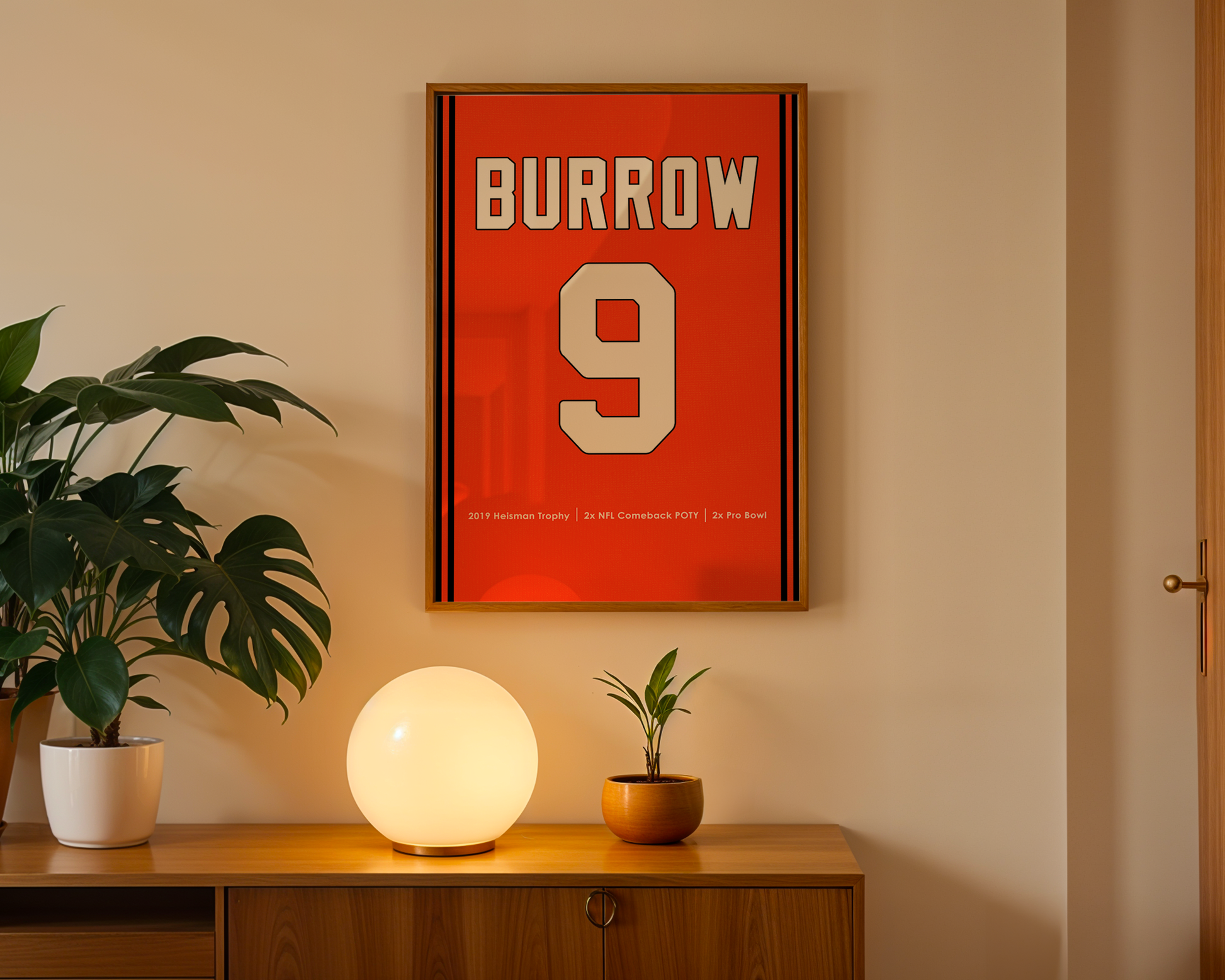 Framed poster with 'Burrow 9' on a wall above a wooden cabinet with decorative items.