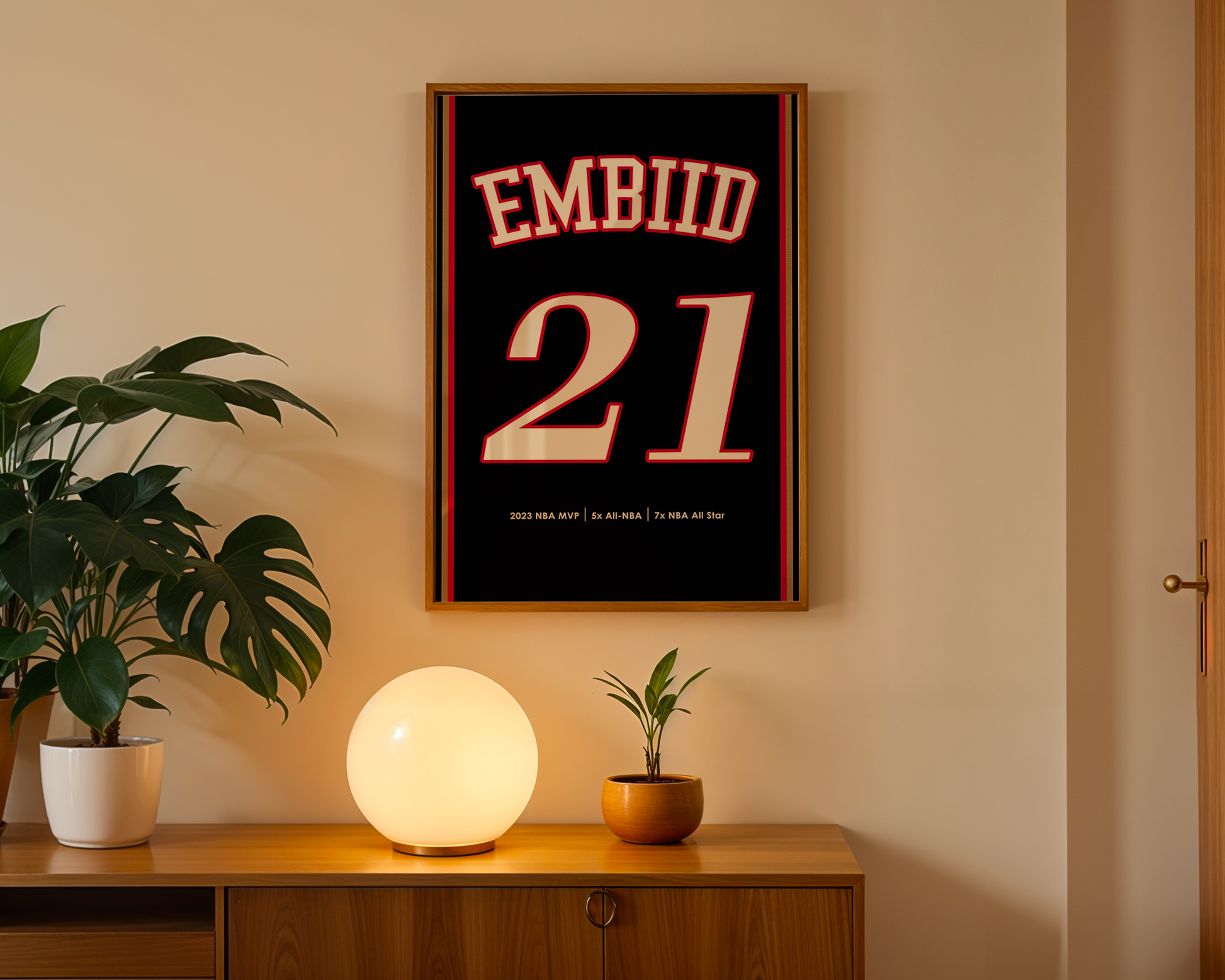 Framed poster with 'EMBIID 21' on a wall above a wooden cabinet with decorative items.