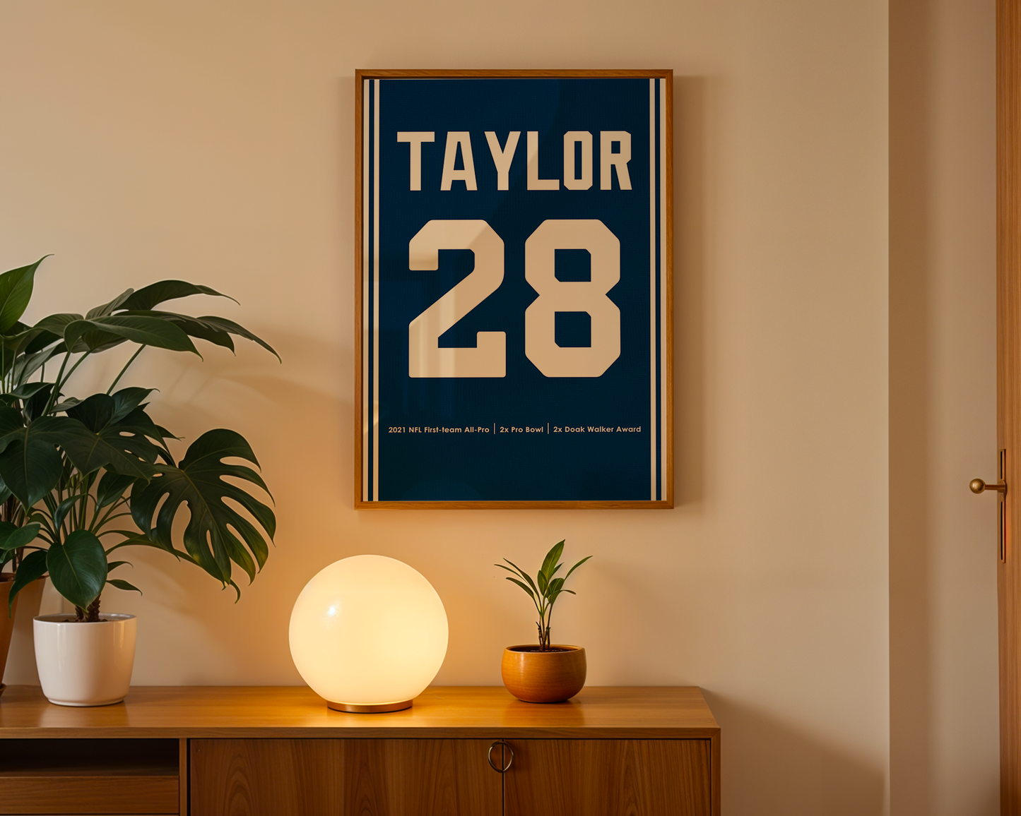 Framed poster with 'Taylor 28' on a wall above a wooden cabinet with decorative items.
