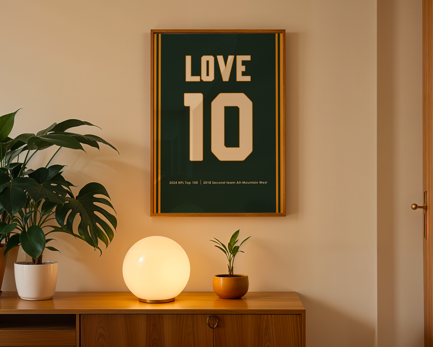Framed poster with 'LOVE 10' on a wall above a wooden cabinet with decorative items.