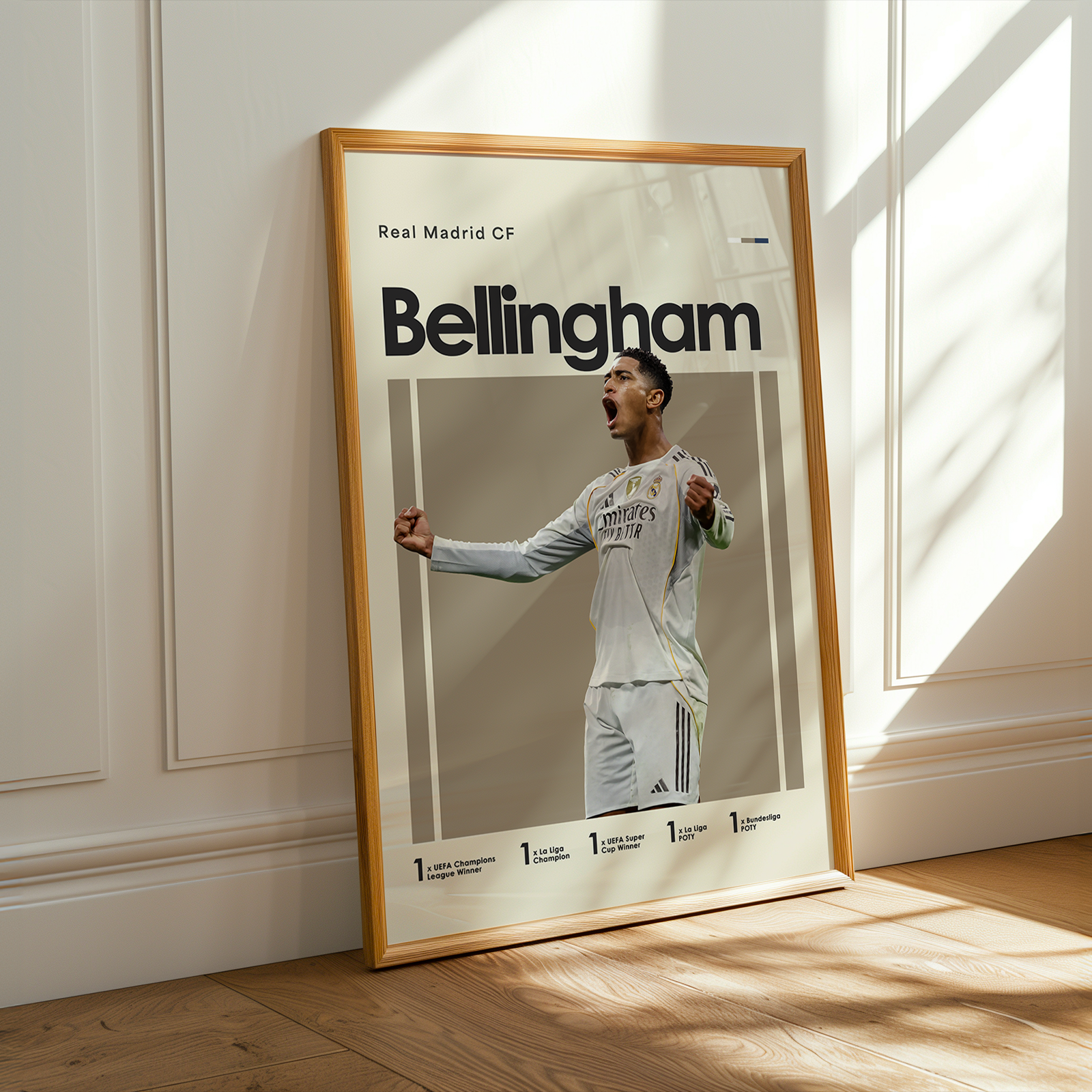 Framed poster of a soccer player with 'Real Madrid CF' and 'Bellingham' text, leaning against a wall.
