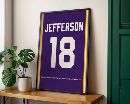 Framed sports jersey with 'Jefferson' and number '18' on a wooden shelf.