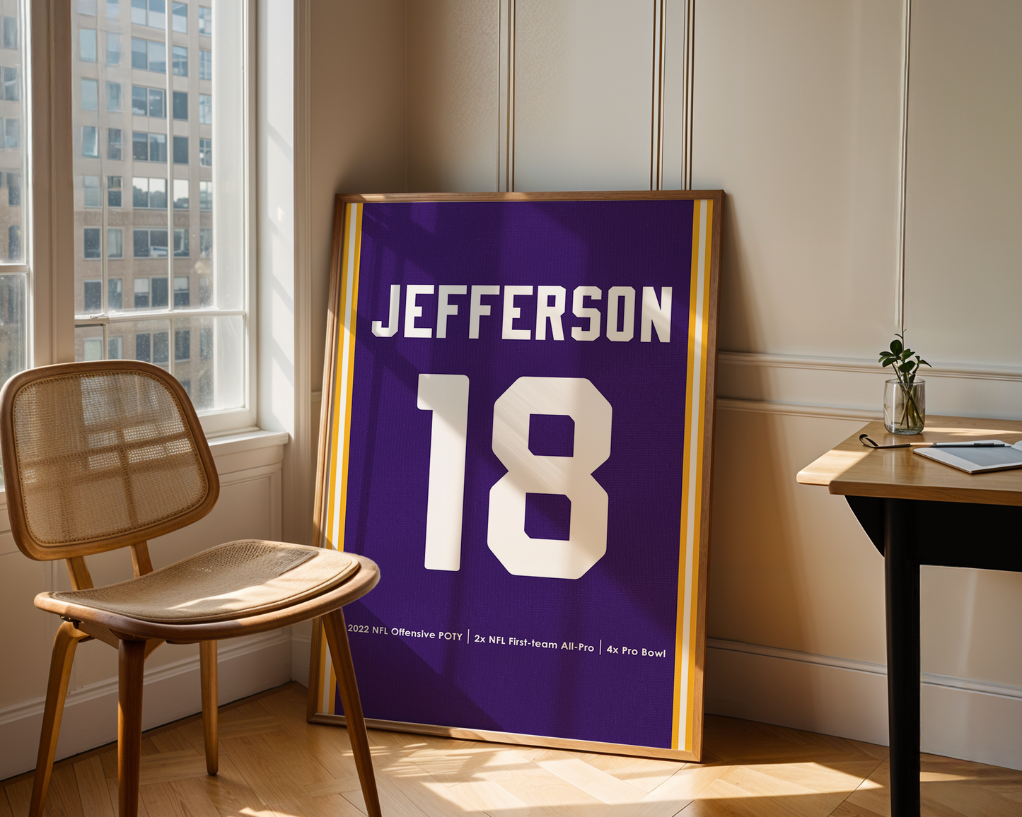 Framed sports jersey with 'Jefferson' and number '18' in a room with a window and chair.