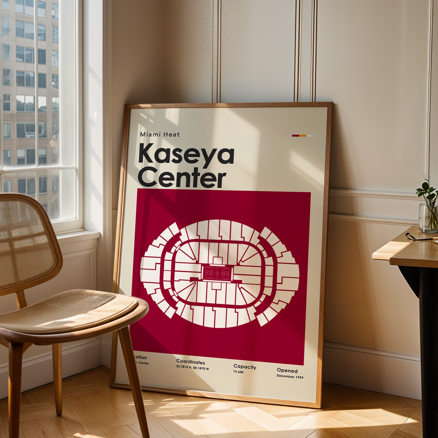 Framed poster of Kaseya Center in a room with a chair and table.