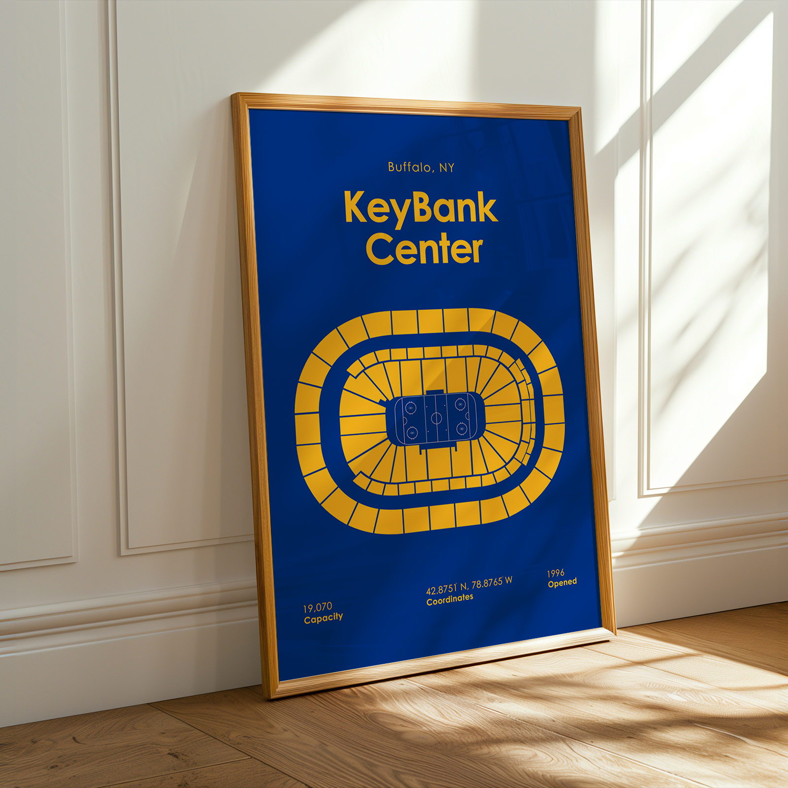 Framed poster of KeyBank Center with blue background and yellow text, displayed on a wall.