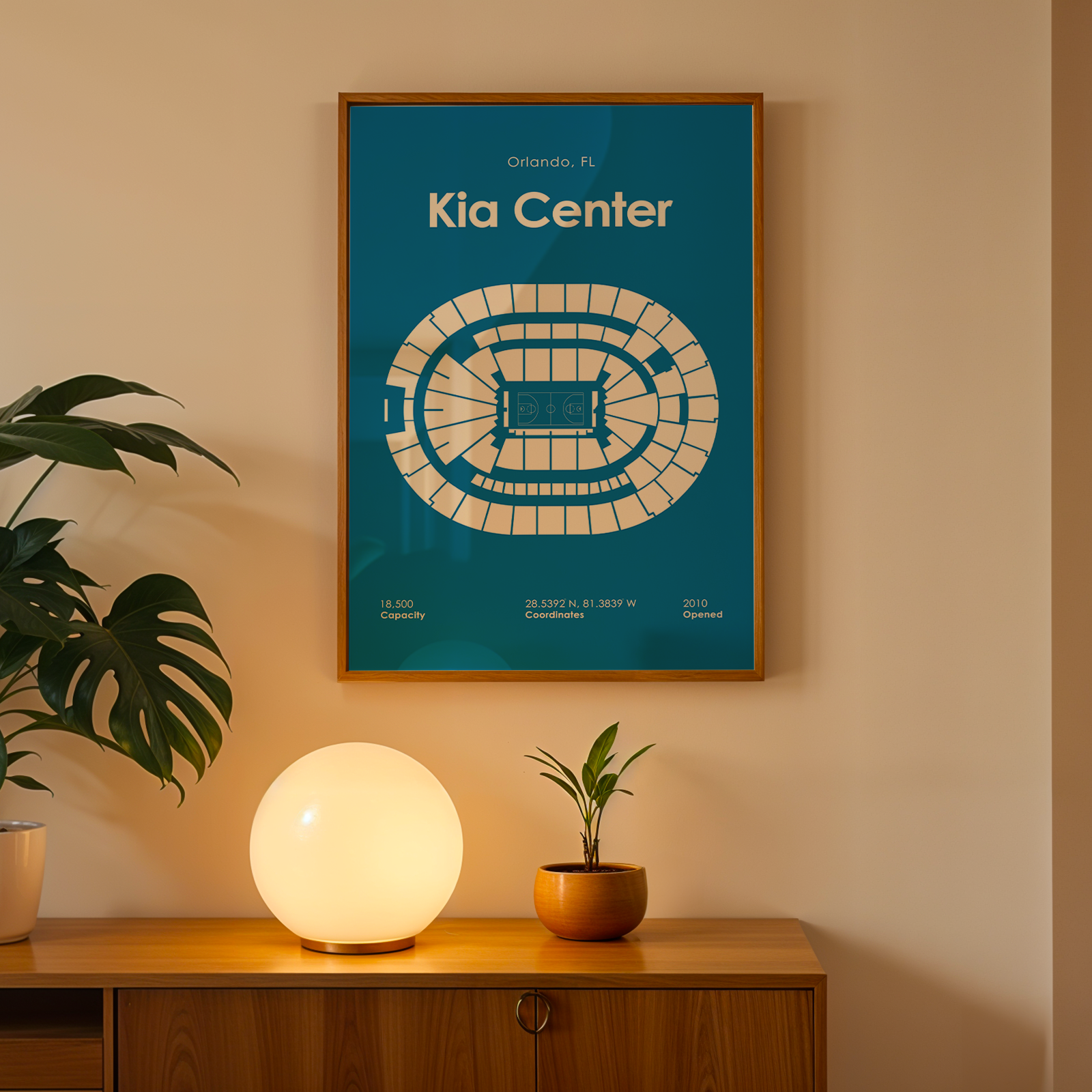 Framed poster of Kia Center on a wall above a wooden cabinet with decorative items.