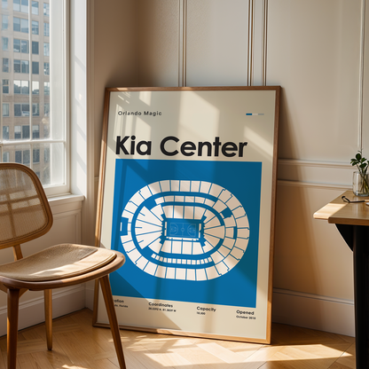 Framed poster of the Kia Center in a room with a chair and table.
