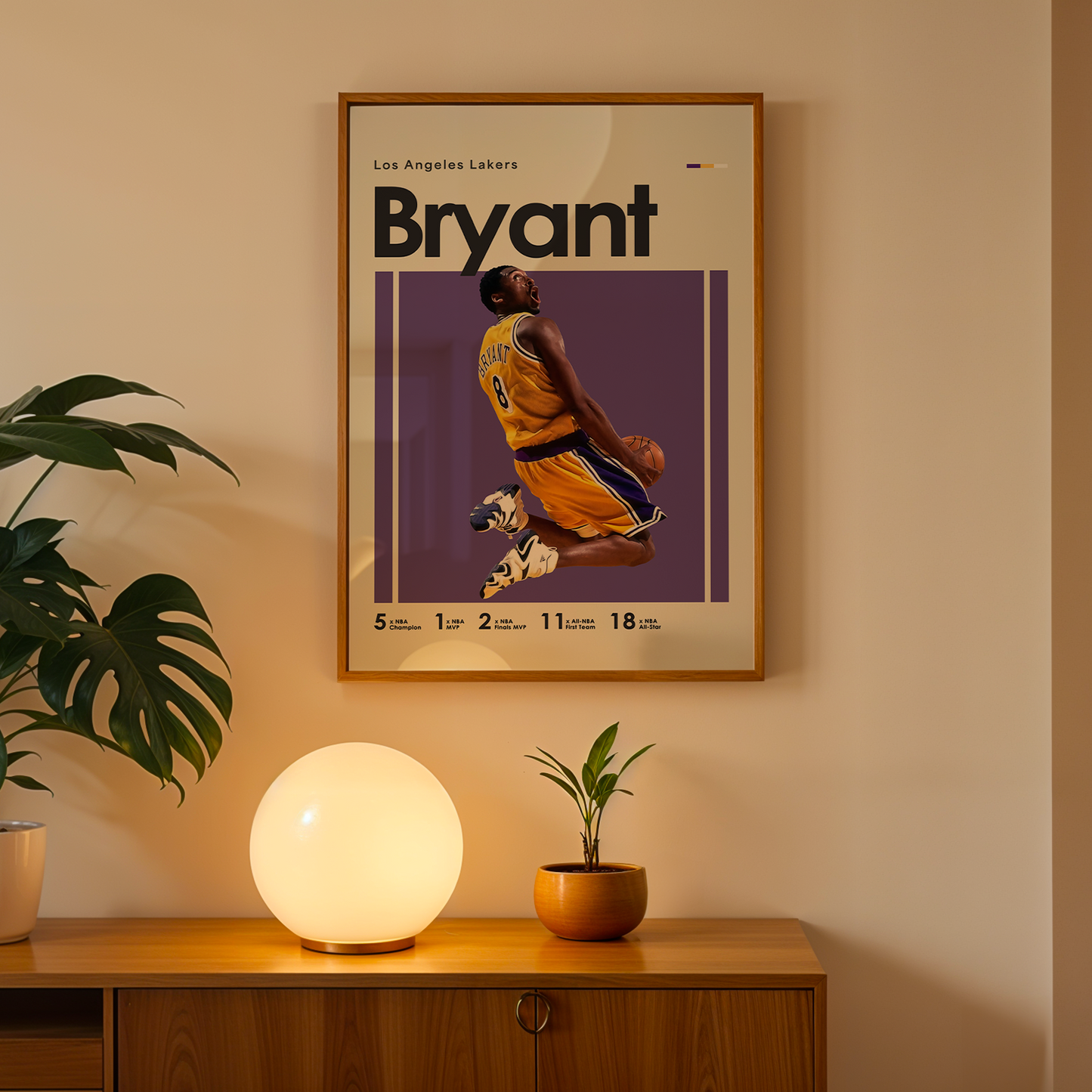 Framed poster of a basketball player with 'Bryant' on a wall above a wooden cabinet with decorative items.