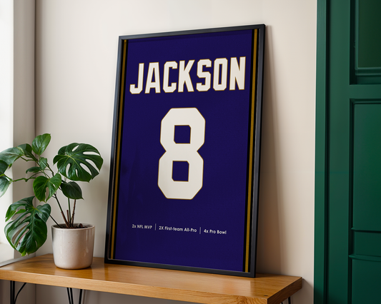 Framed sports jersey with 'Jackson' and number '8' on a wooden shelf.