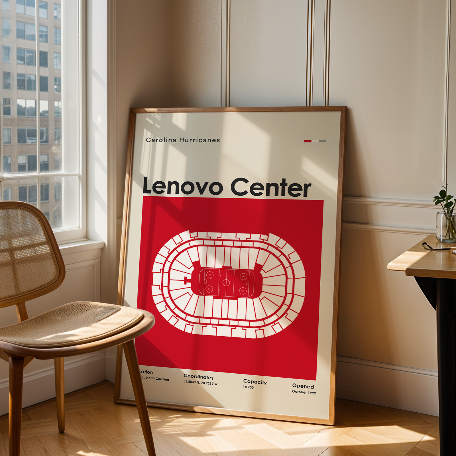 Framed poster of Lenovo Center in a room with a chair and table.
