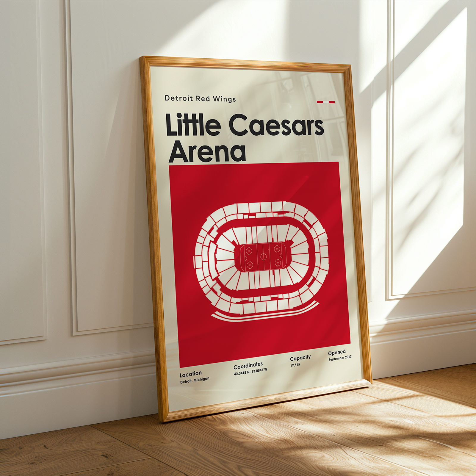 Framed poster of Little Caesars Arena with Detroit Red Wings branding on a wooden floor.