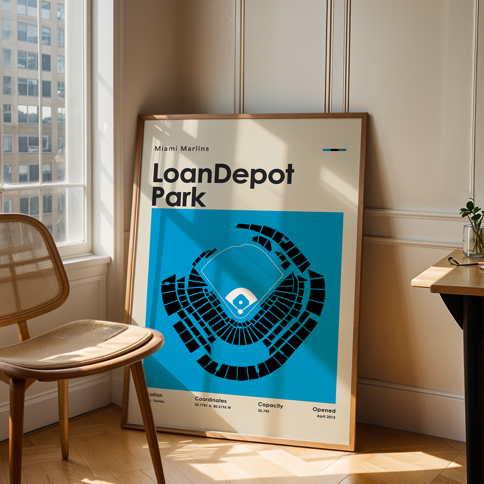Framed poster of LoanDepot Park in a room with a chair and table.