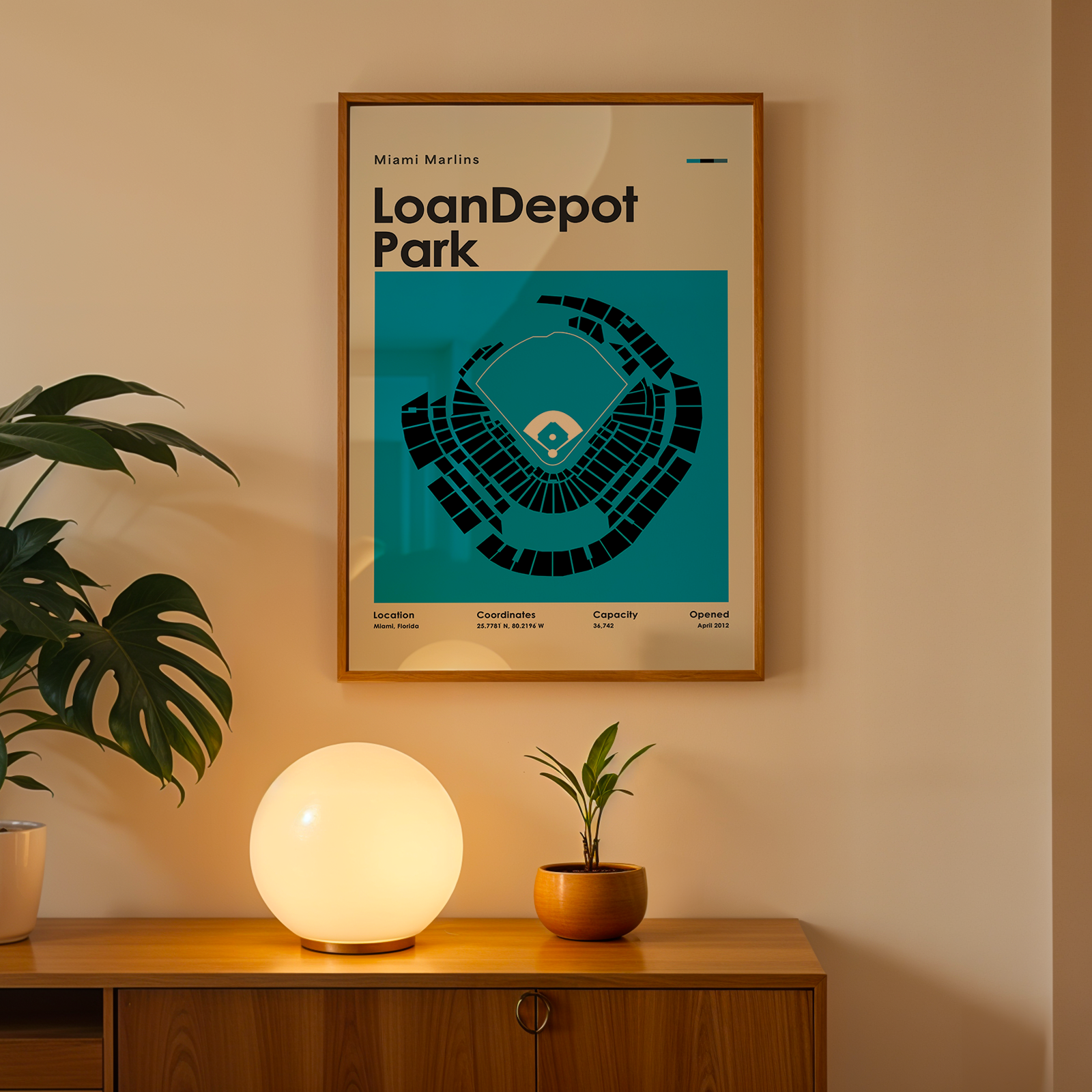 Framed poster of LoanDepot Park on a wall above a wooden cabinet with decorative items.