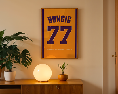 Framed poster with 'DONCIC 77' on an orange background, placed above a wooden cabinet with decorative items.