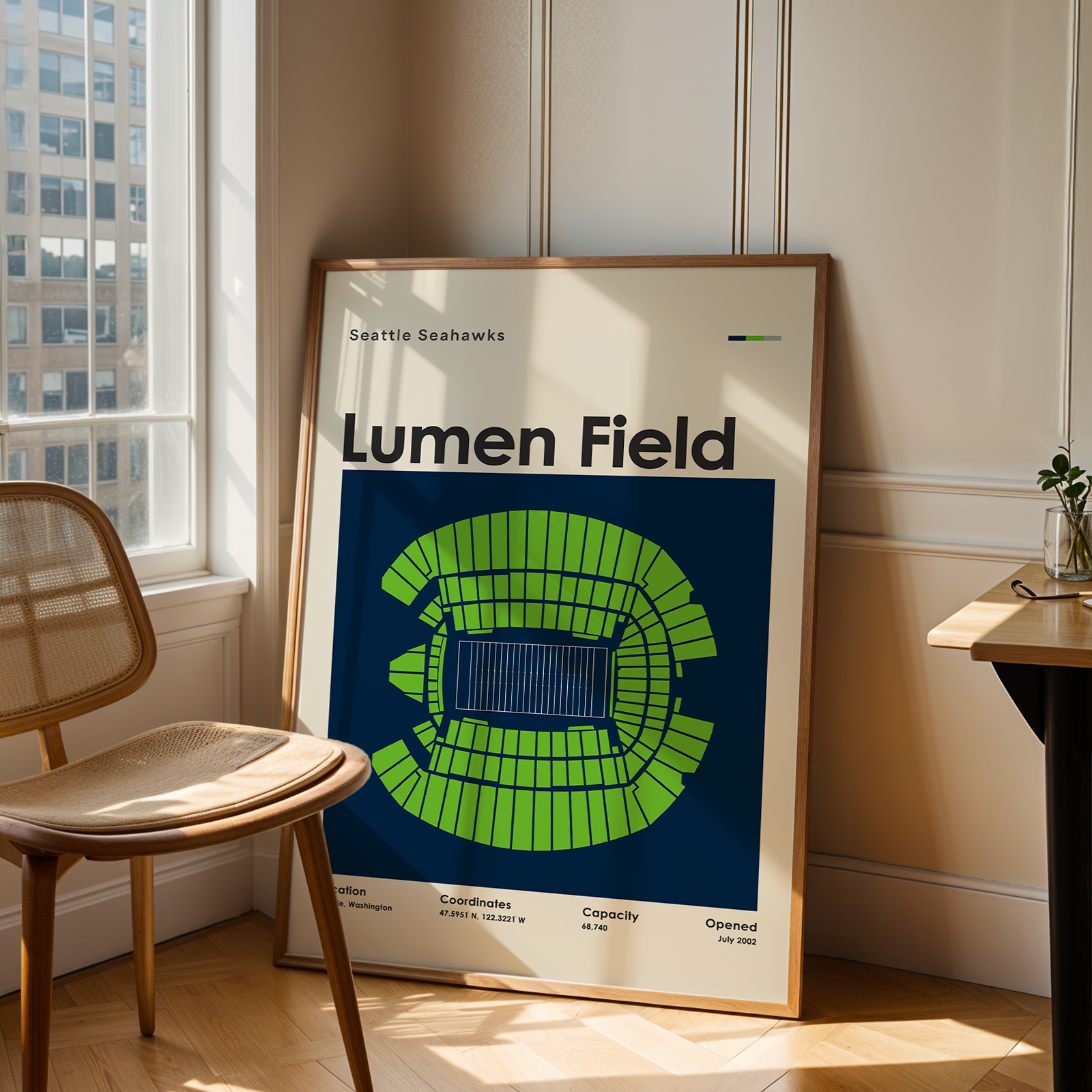 Framed poster of Lumen Field with seating chart in a room with a window and chair.