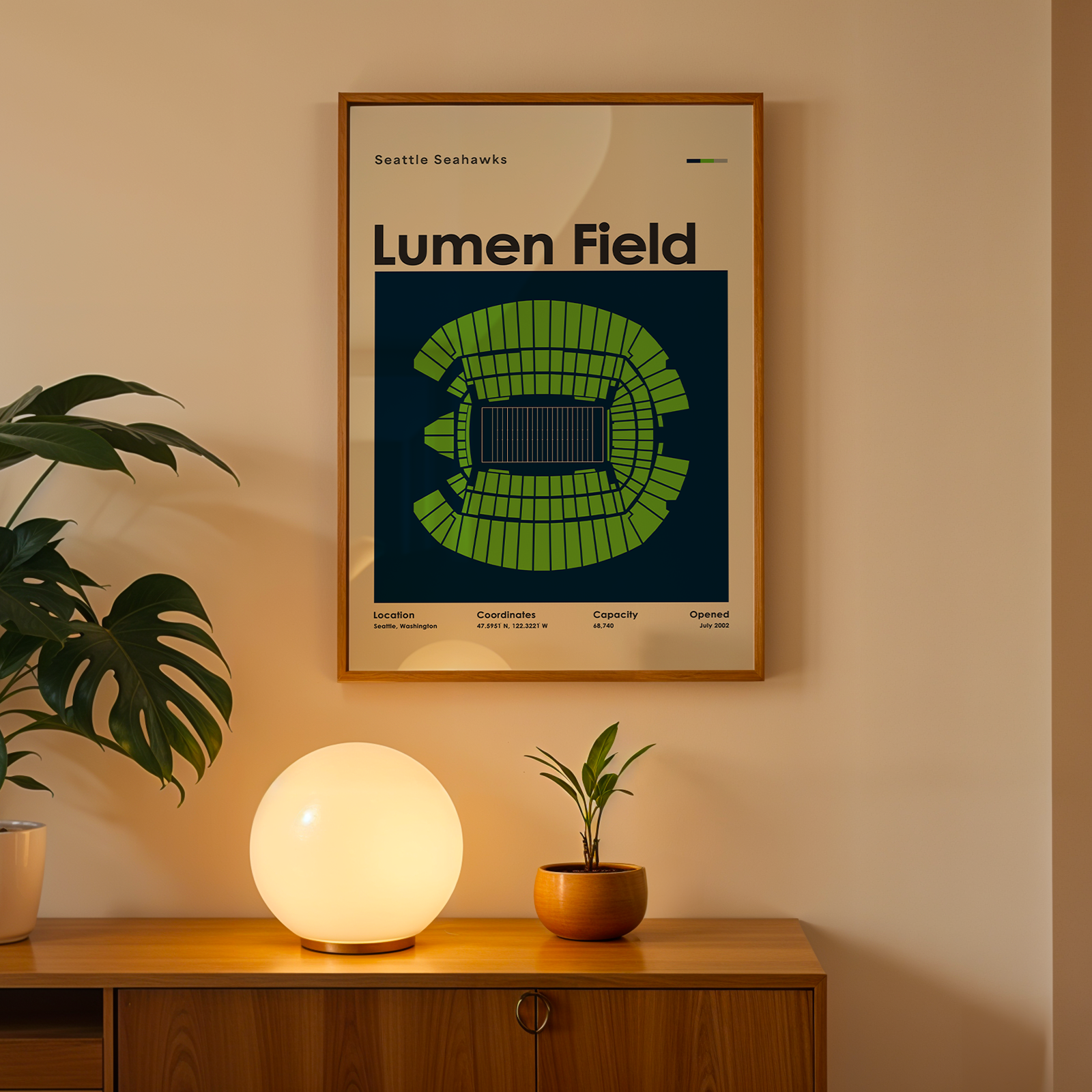Framed poster of Lumen Field on a wall above a wooden cabinet with decorative items.