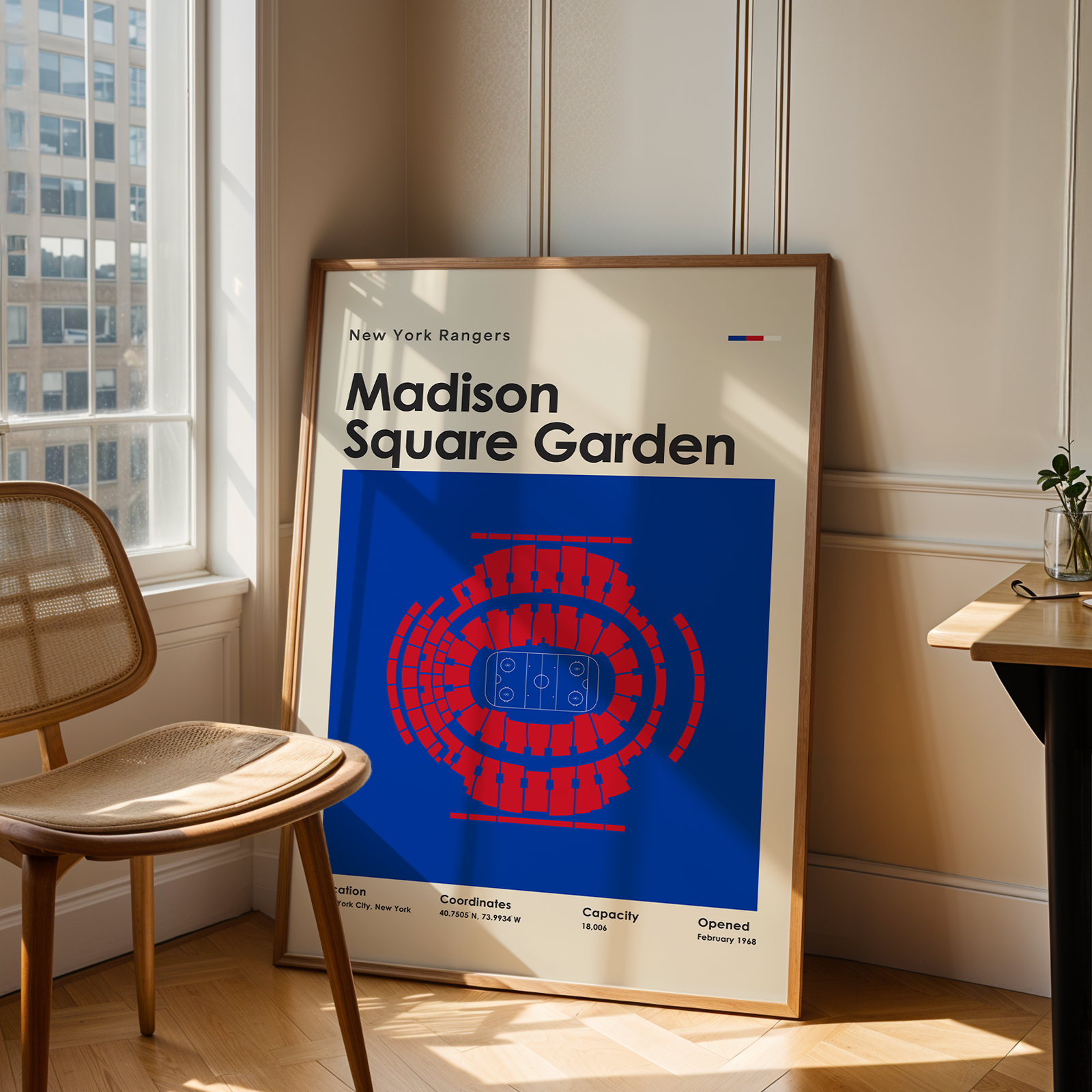 Framed poster of Madison Square Garden in a room with a chair and table.