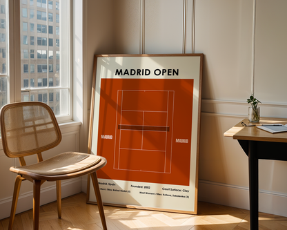 Framed poster of the Madrid Open tennis tournament in a room with a chair and table.