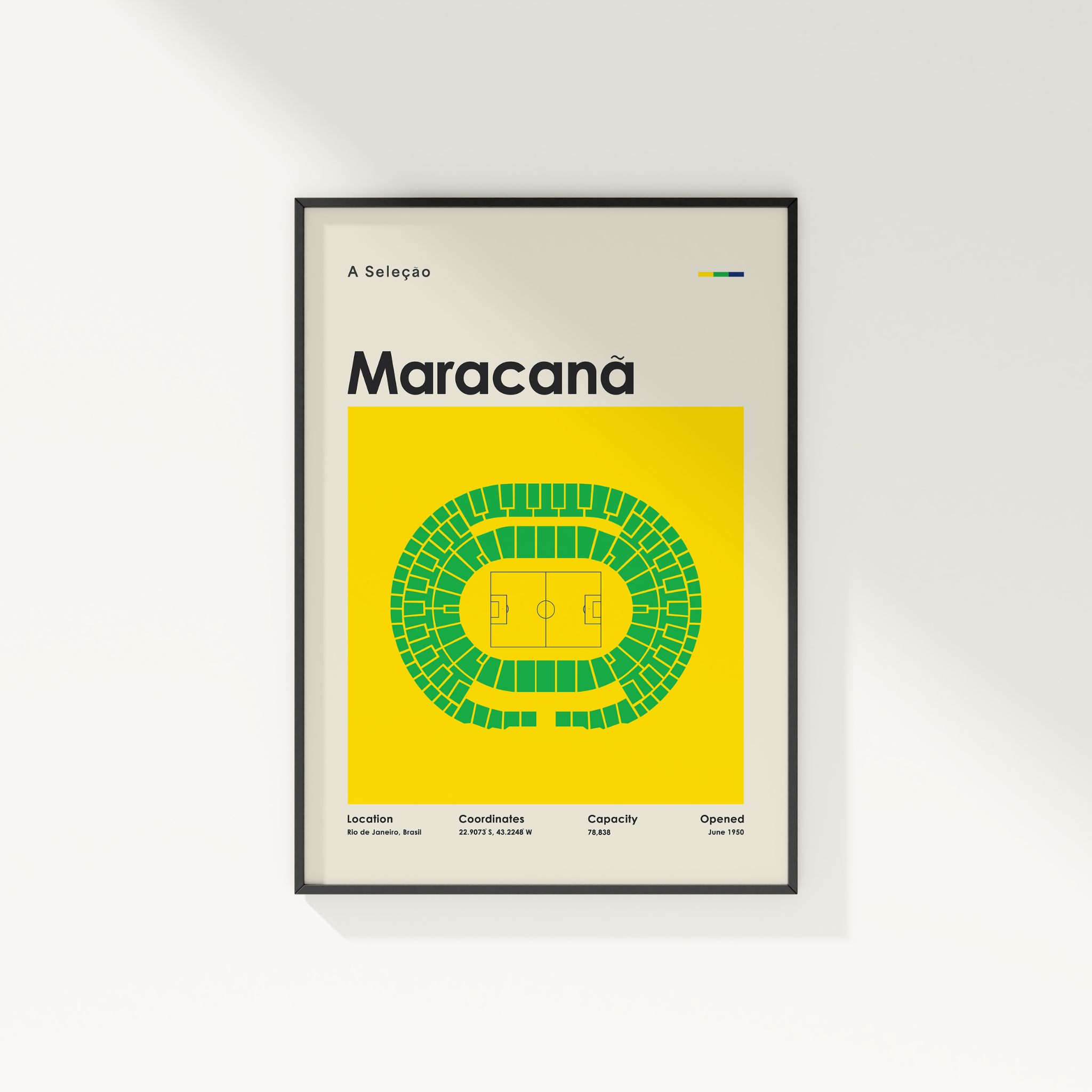 A framed minimalist sports poster for the Maracanã stadium in Brazil, featuring a yellow background, green stadium seating diagram, and black text, displayed on a clean white wall.