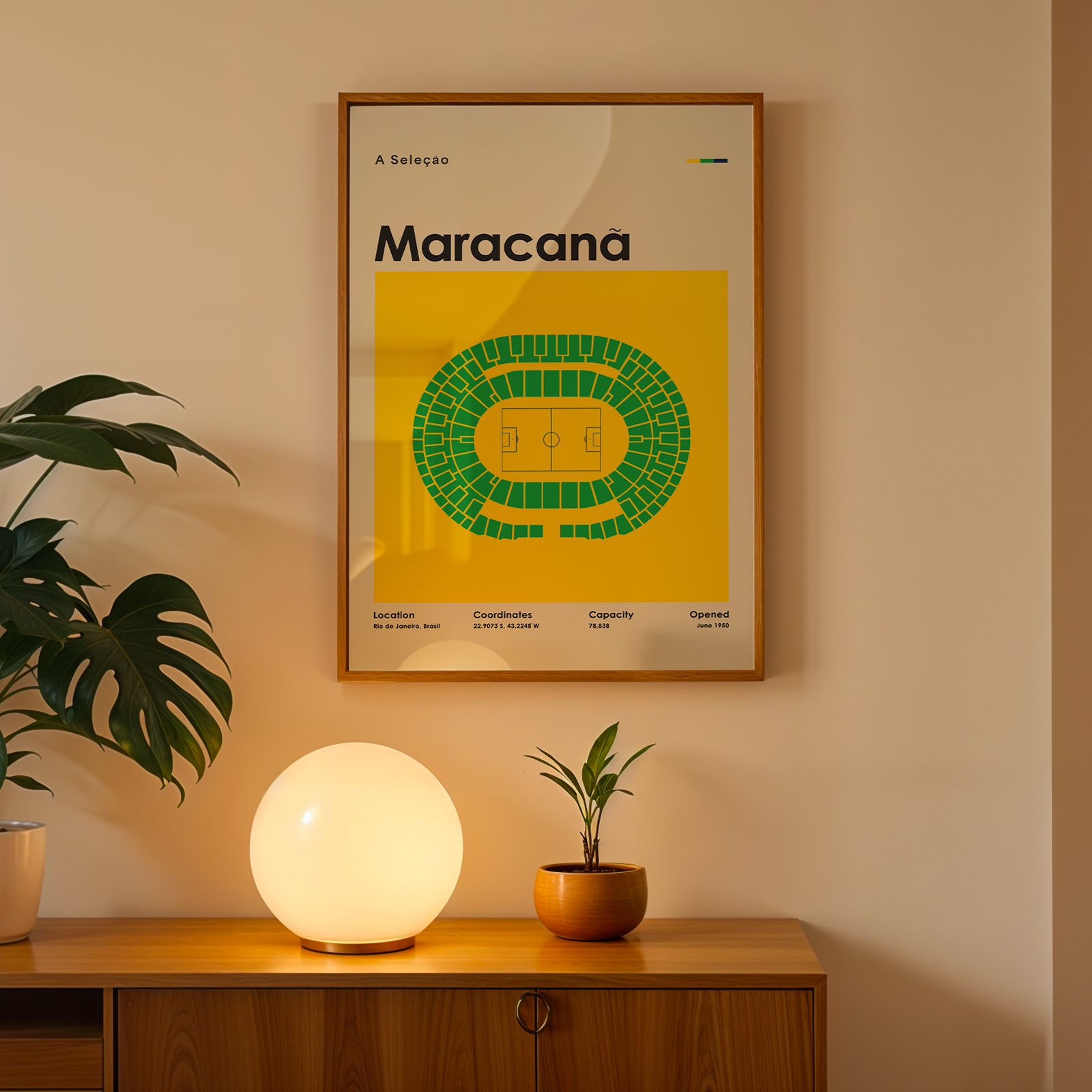 A framed Maracana sports poster hangs on a beige wall above a wooden console table. The poster features a bright yellow background with a green stadium diagram and the word 'Maracana' in bold.