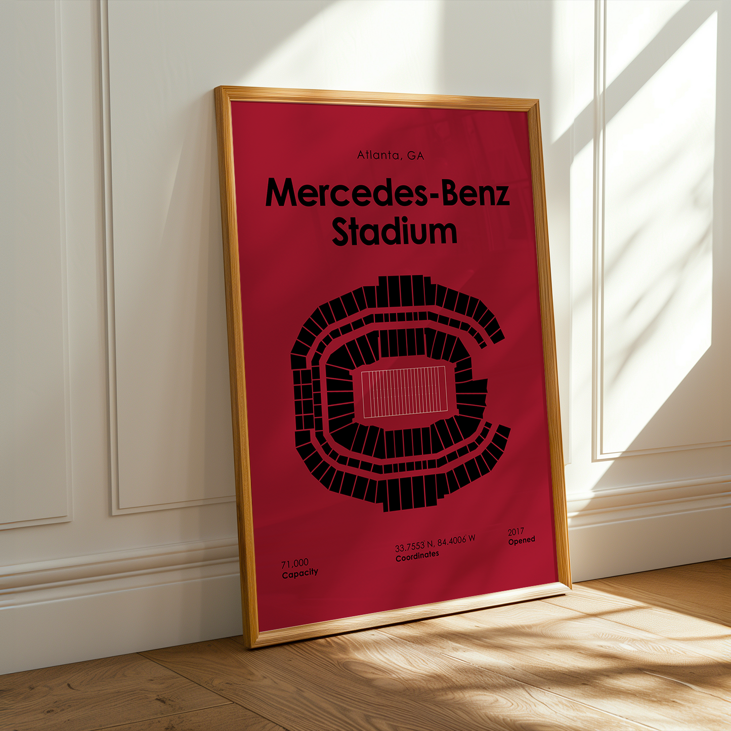 Framed poster of Mercedes-Benz Stadium on a wall with sunlight casting shadows.