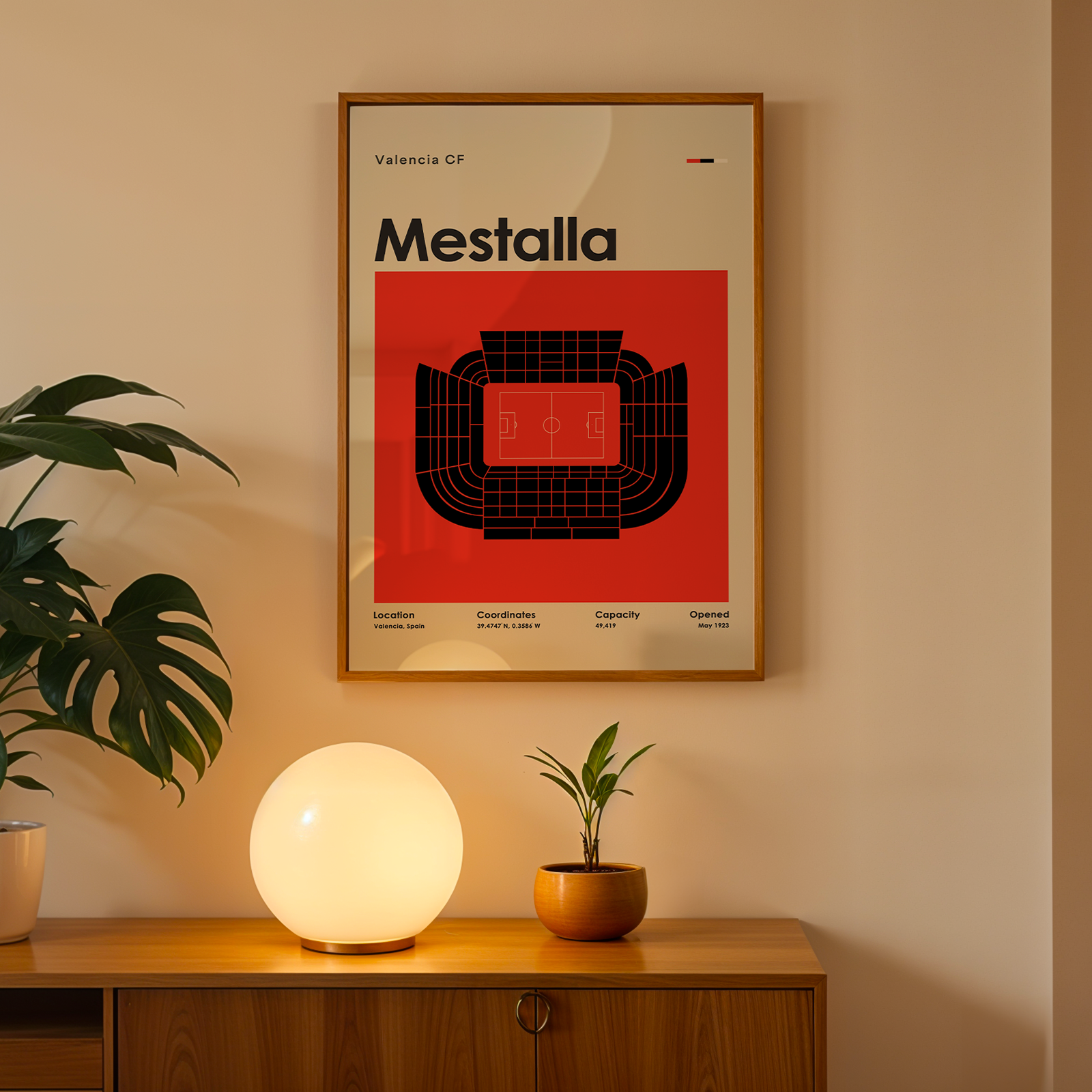 Framed poster with 'Mestalla' design on a wall above a wooden cabinet with decorative items.